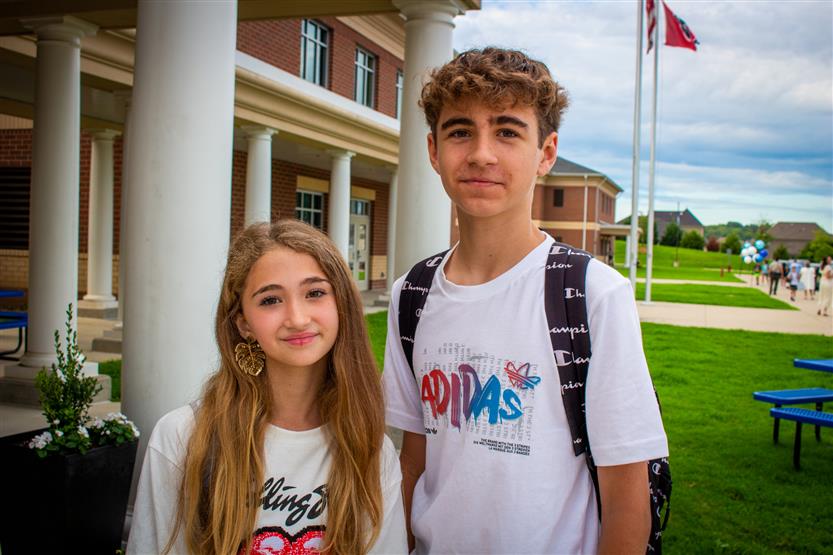 A boy and girl smile on the first day of school